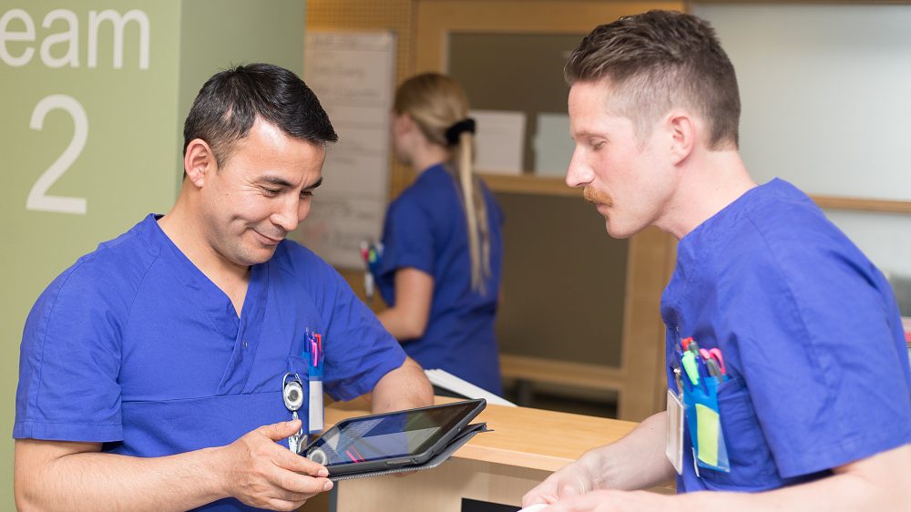 Sjuksköterskor med läsplatta och papper