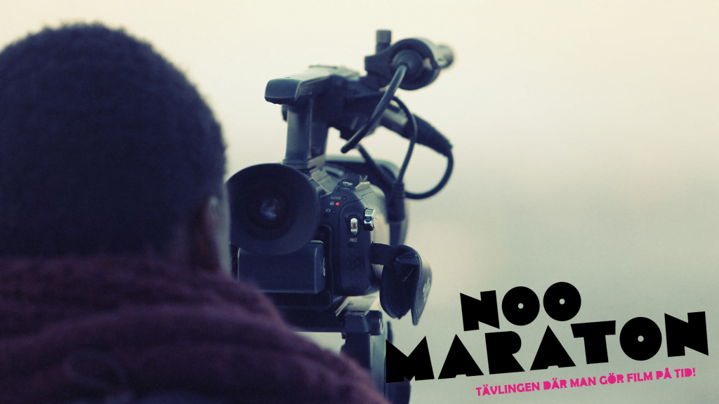 Bild på man som står med en filmnkamera.