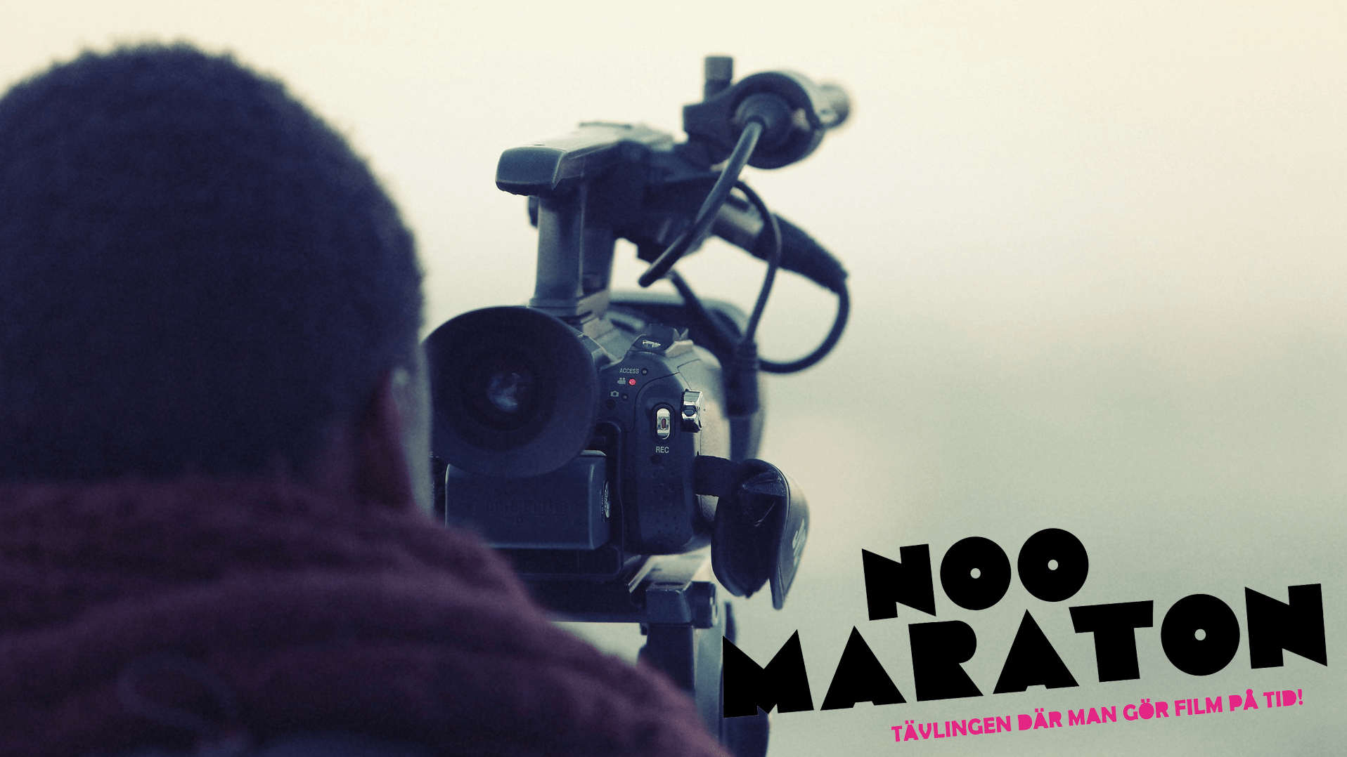 Bild på man som står med en filmnkamera.