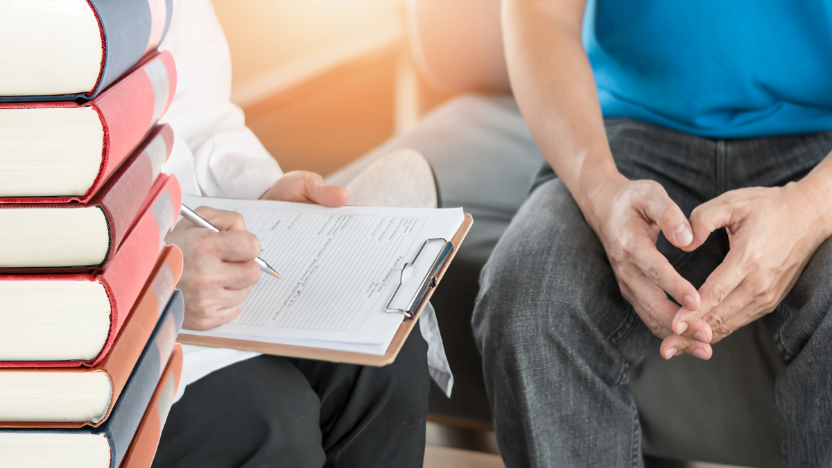 Bild p åböcker och en patient och läkare s händer som sitter i samtal