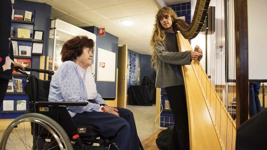 Maj-Britt Wallin passade på att ta sig en närmare titt på Liv Dahréns harpa. Musiken fick henne att minnas hur hon som barn satt på golvet hos grannen och hörde deras tre musikaliska döttrar spela. Foto: Anna Rehnberg