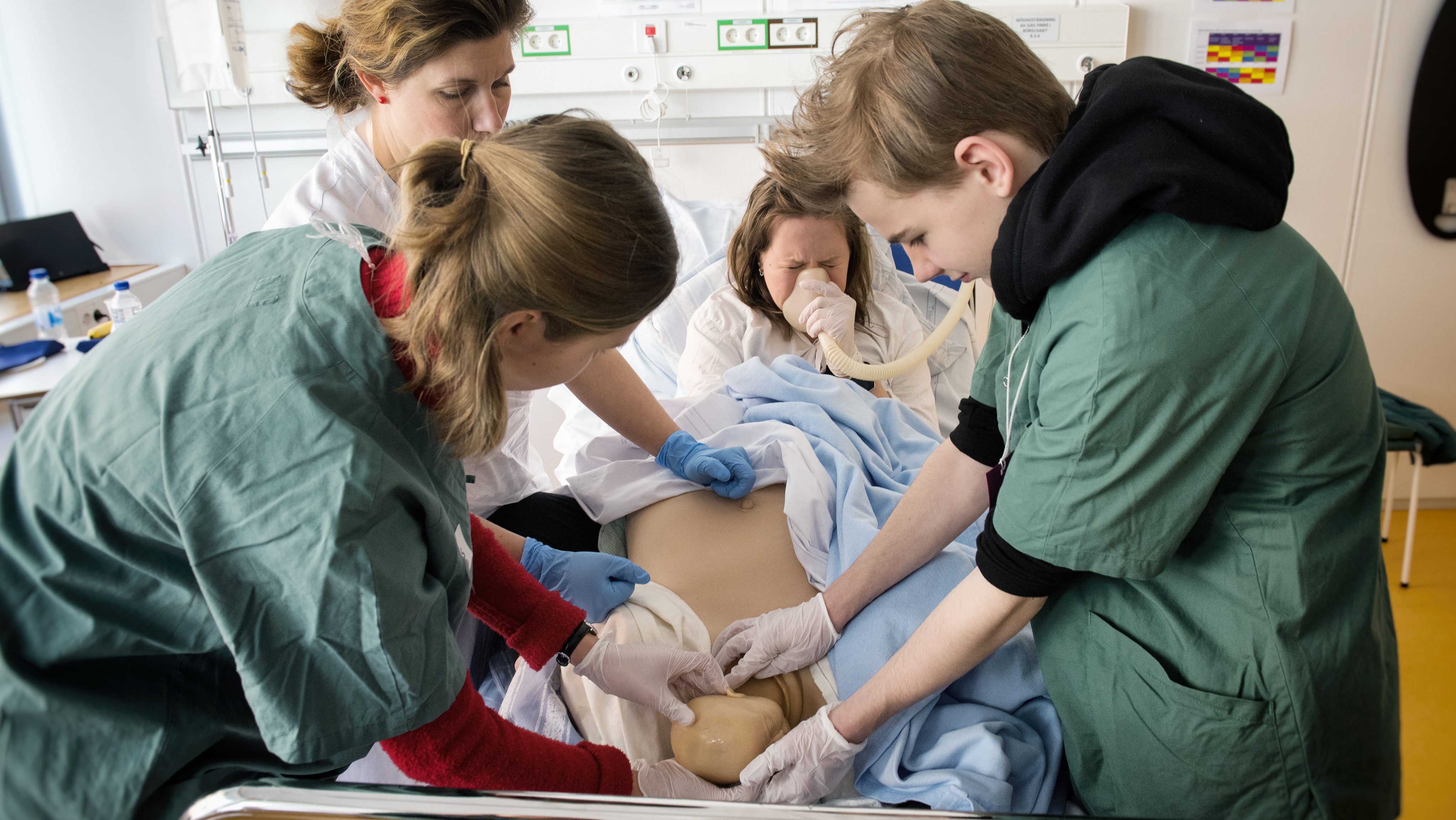 Barnmorskan Linda Ivansson instruerar Agnes Frimannsson och Eben Weilenmann under en simulerad förlossning på Simulatorcentrum. Foto: Anna Rehnberg