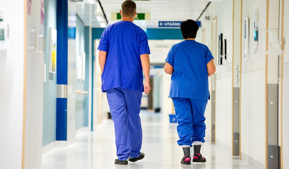 Vårdpersonal som går i en sjukhuskorridor.