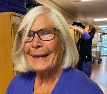 Britt Svensson, distriktssköterska på Närhälsan Tjörn står arbetsklädd i en korridor på sin arbetsplats