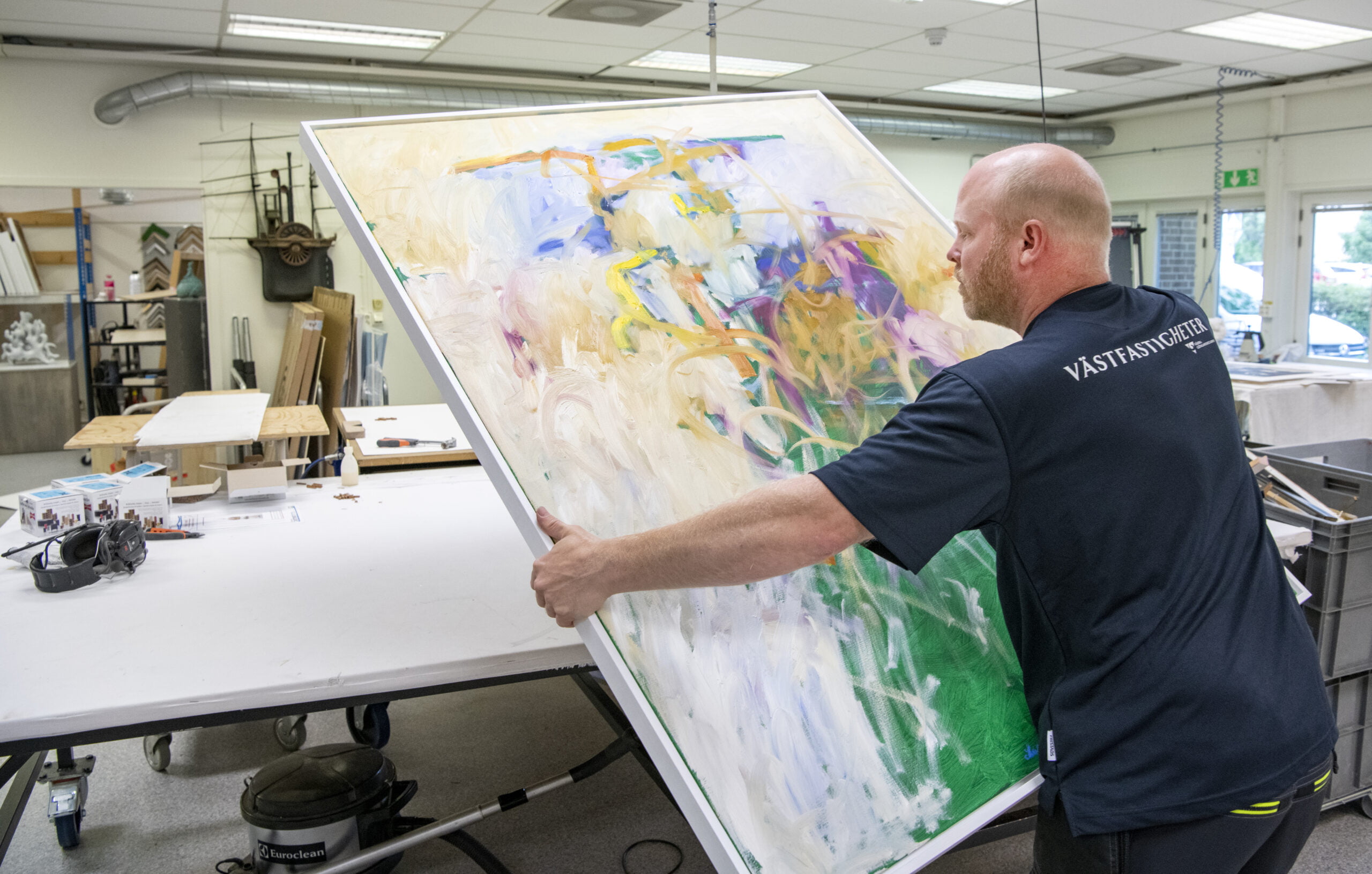 En stor oljemålning av Vänersborgskonstnären Bengt Johansson har kommit in för att få en ny ram. Foto: Kent Eng