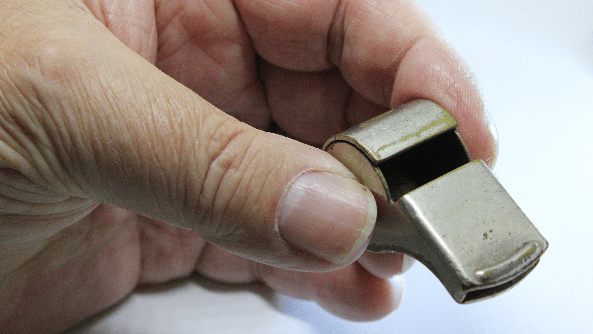 En hand håller i en visselpipa