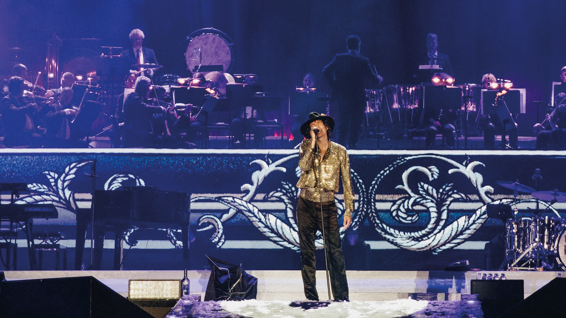 Artisten Håkan Hellström står på en scen med GöteborgsOperans orkester bakom.