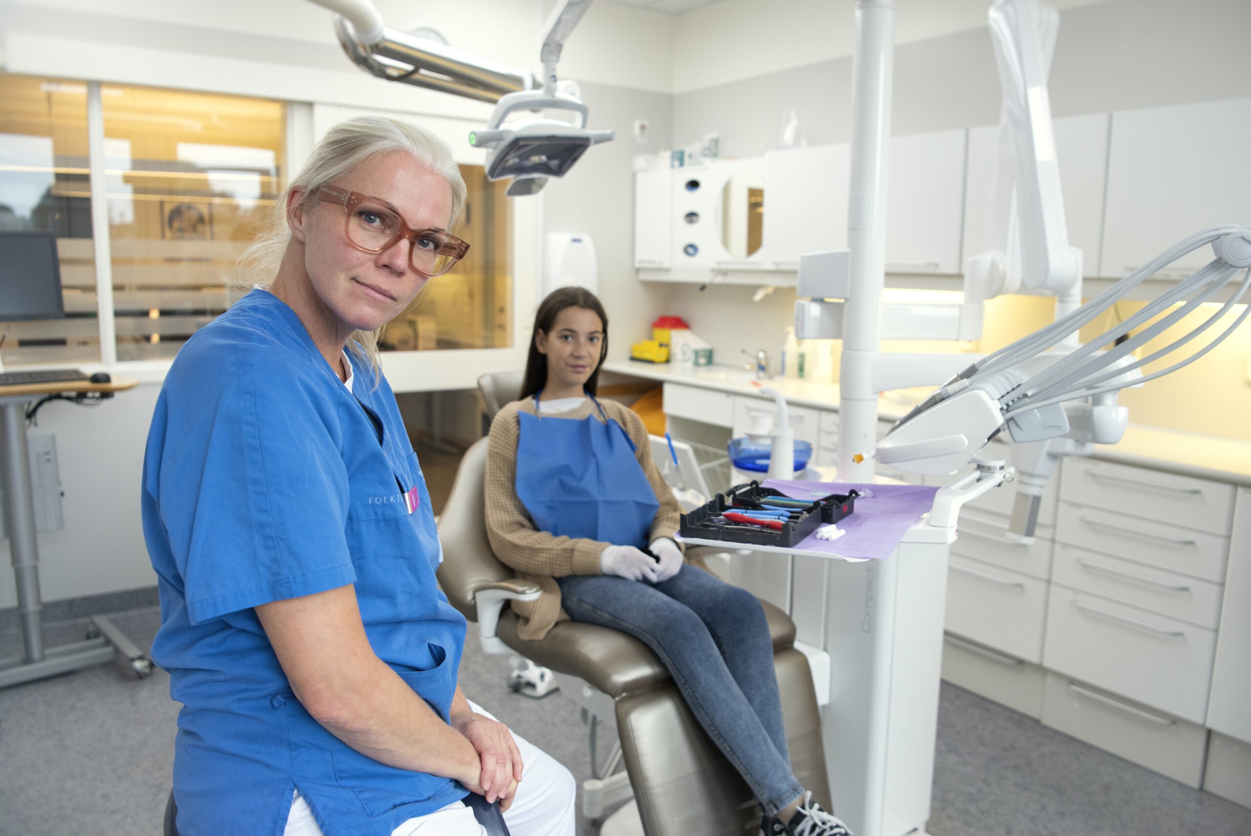 Natalie Tilldal sitter i tandläkarstolen och i förgrunden syns tandhygienisten Josephine Peterson.e