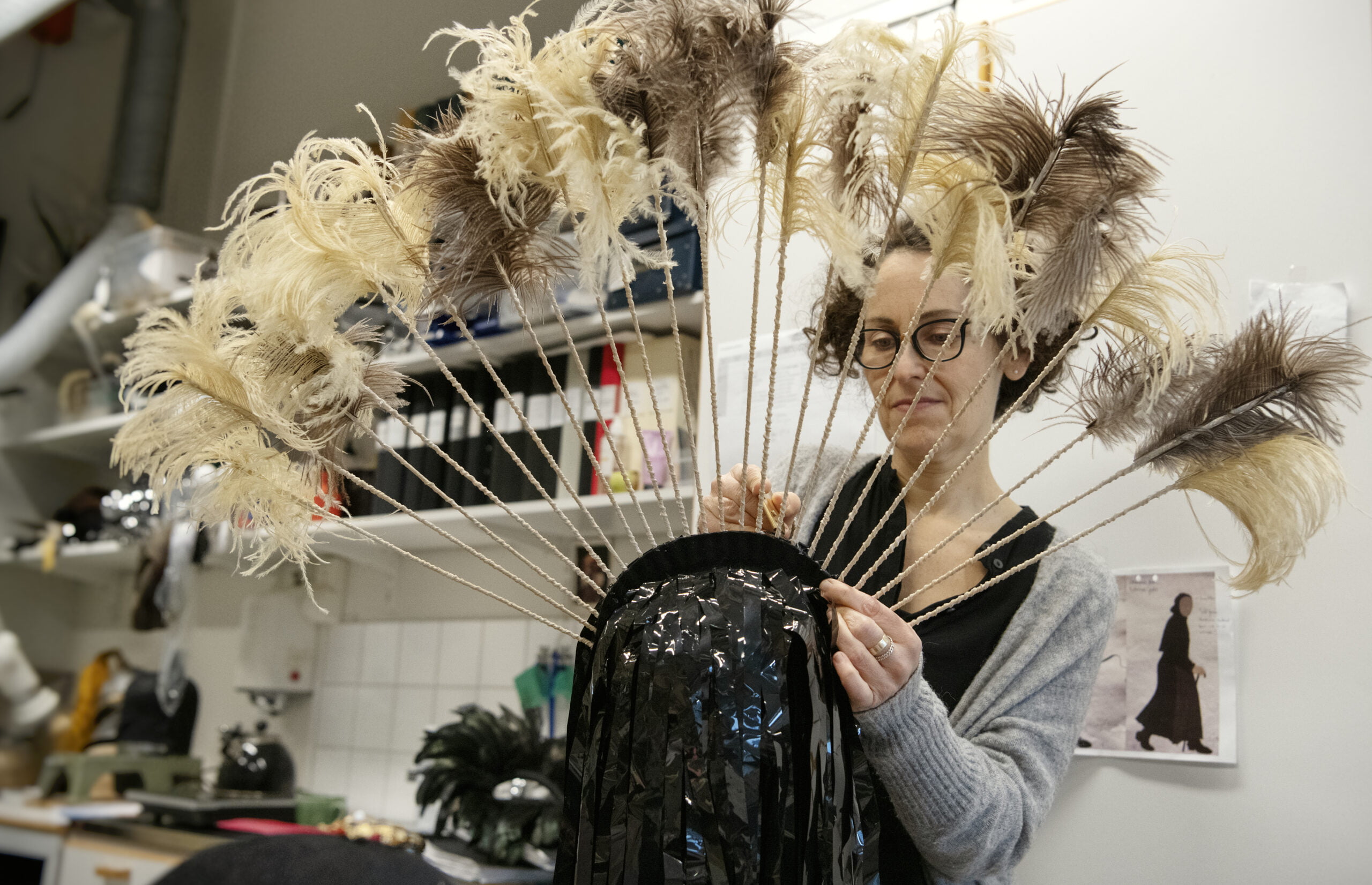 En huvudbonad från Kärlek skonar ingen har kommit in på service. Artisten behöver ha en hårdare resår under hakan och några av pinnarna med fjädrar har släppt. Foto: Anna Rehnberg