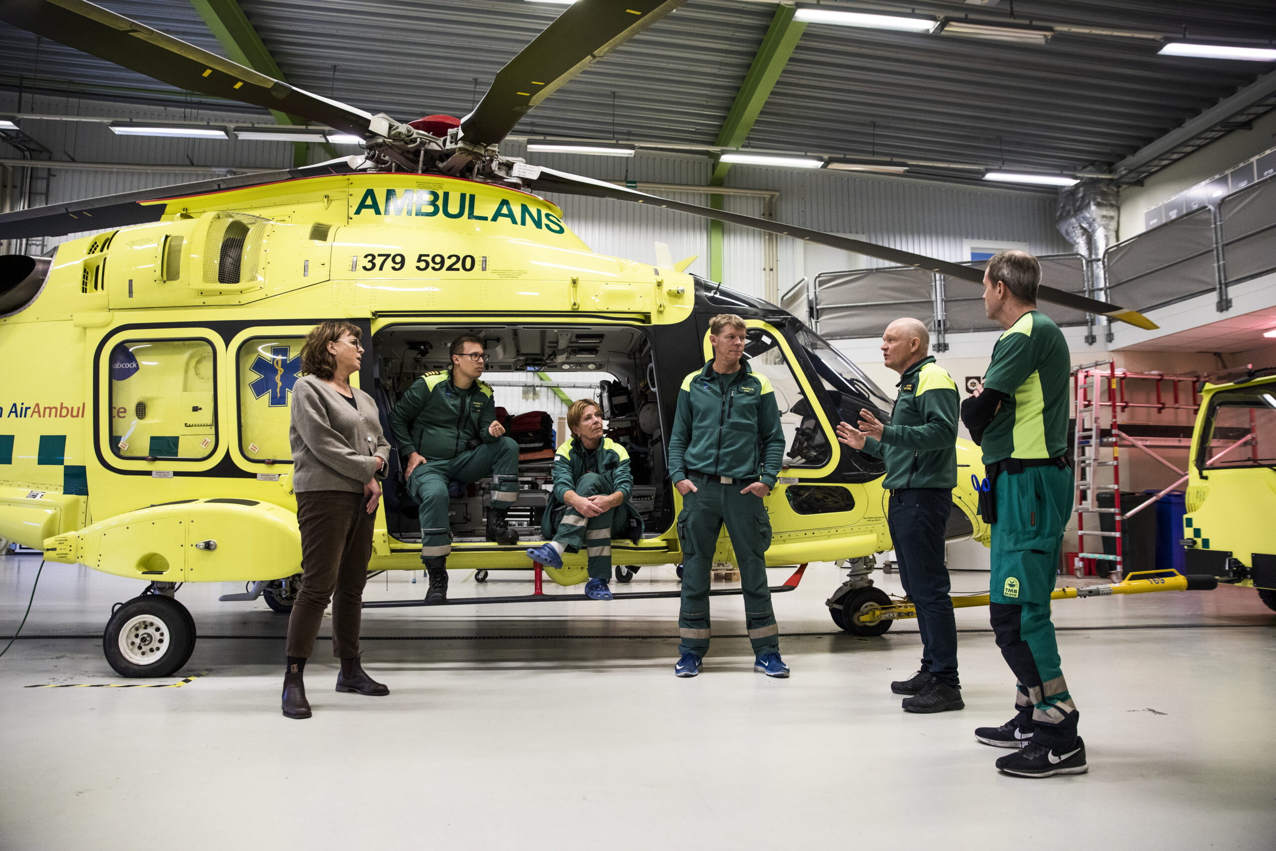 Ambulanshelikoptern står på golvet med personal utanför. Bilden är från när sjukhusdirektör Ann-Marie Wennberg besökte verksamheten.