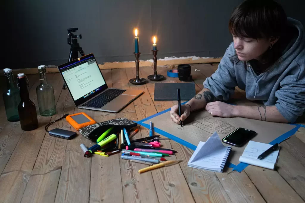 Sian Hedberg arbetar med sin konst vid ett bord.