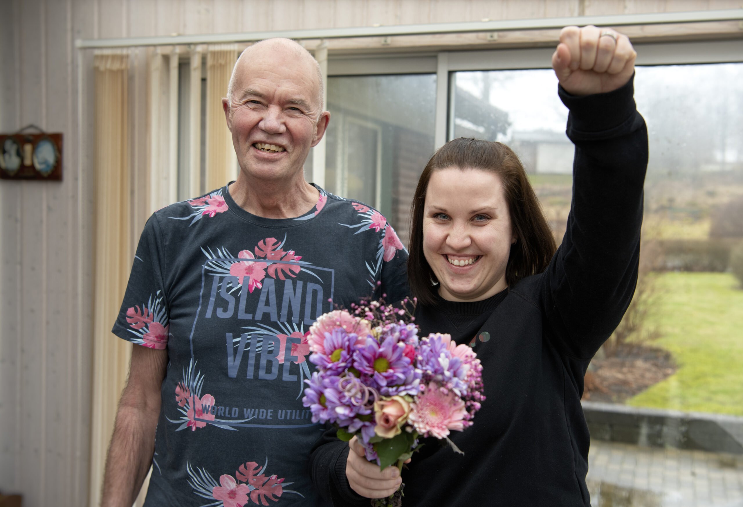 Conny och Lina. Lina håller i en bukett blommor hon fått av Conny och håller upp armen som en superhjälte.