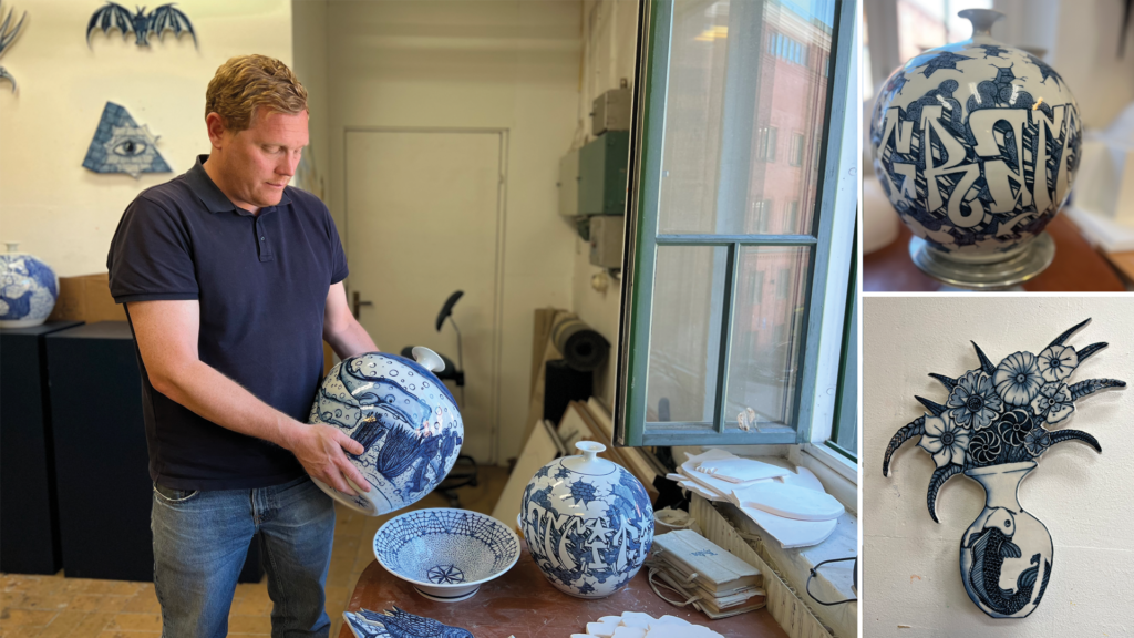 En man står i en konstnärstudio och håller fram en vit och blåfärgad porslinsvas.