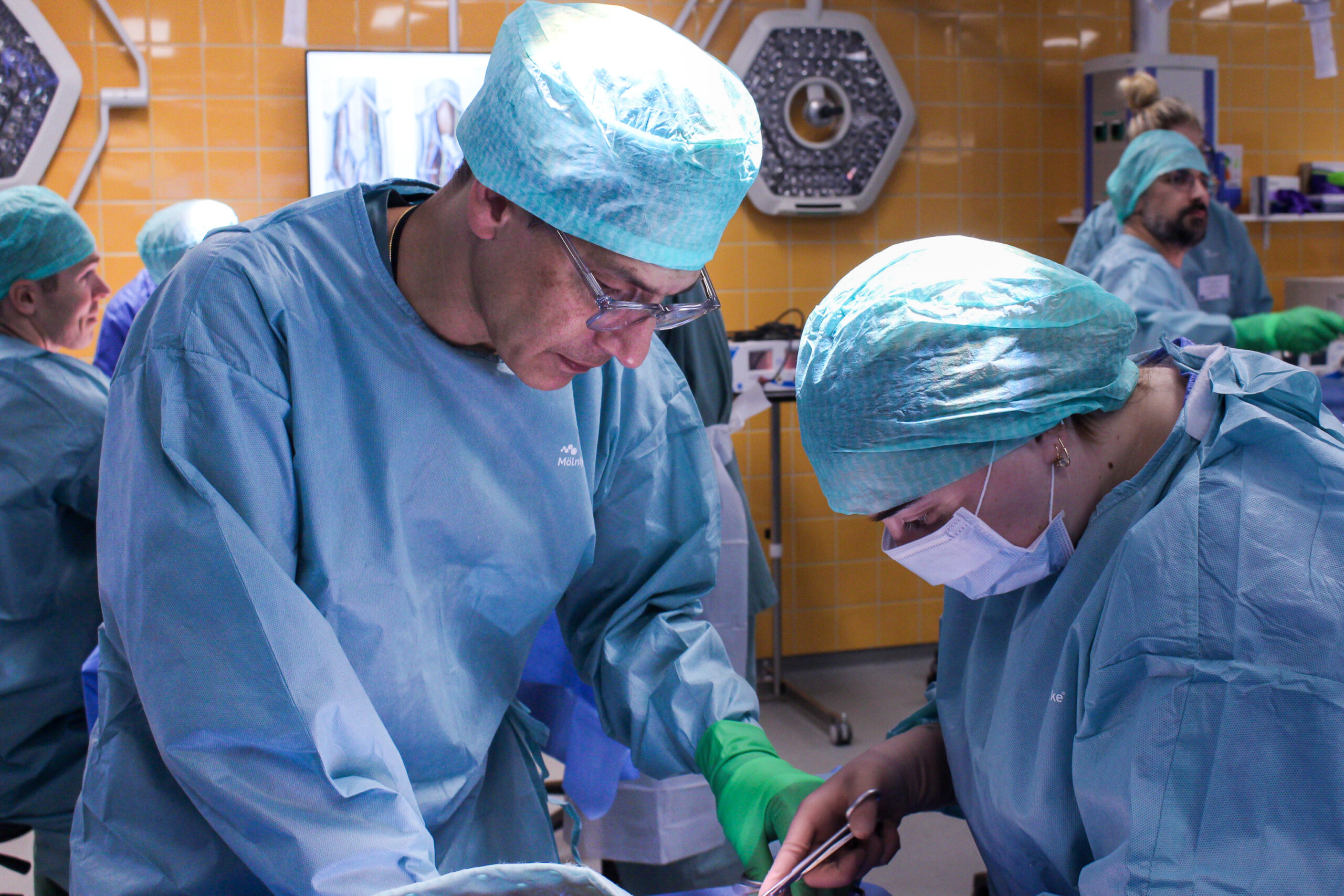 Två läkare står och opererar