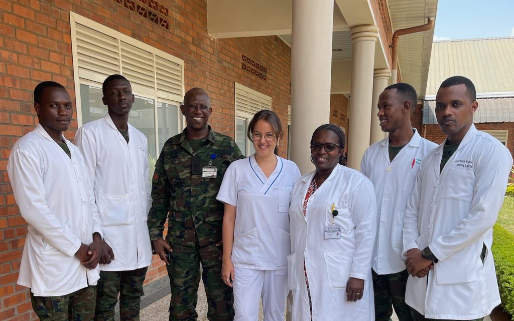 Inès Naouar står tillsammans med vårdpersonal från Rwanda utanför en byggnad.