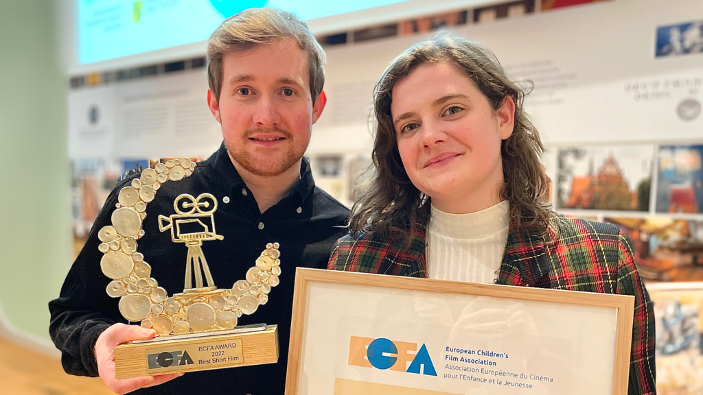 Porträttbild p å Christian och Liselotte som håller upp ett filmpris